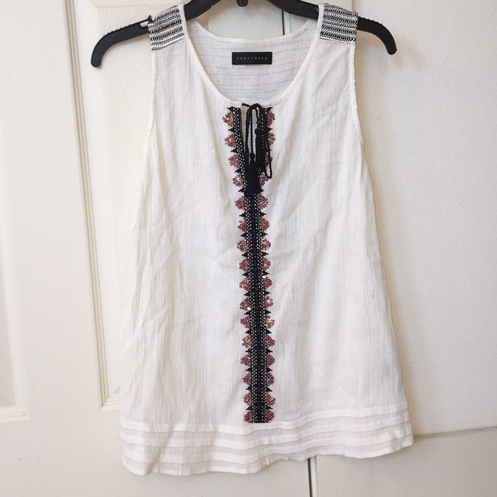A white tank top with pink and gold embellishments